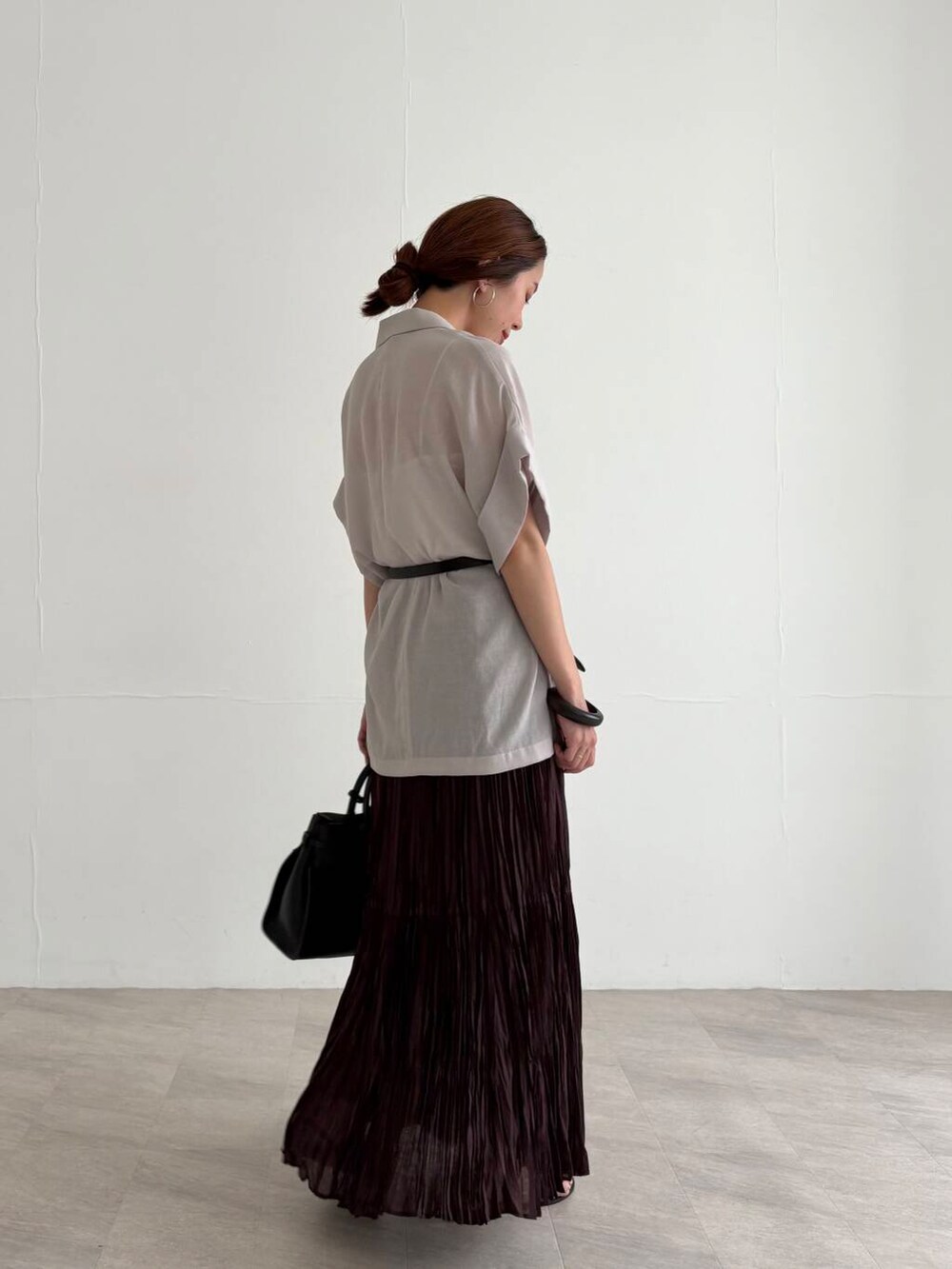 ホワイト系のキャミソール、ブラウン系のスカート、ブラック系のサンダルを着用したレディースの夏コーディネートの5枚目の写真