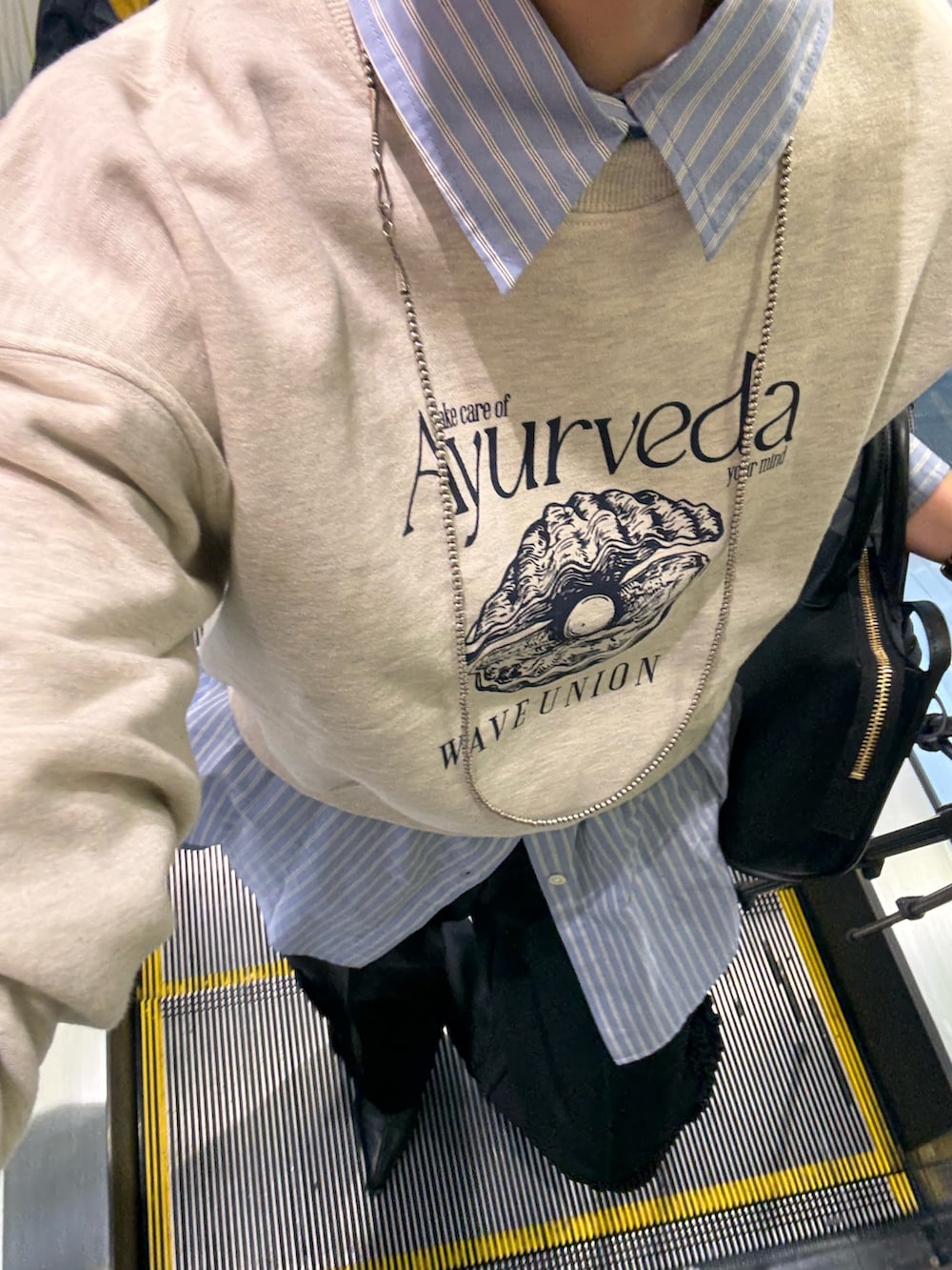 ベージュ系のスウェット、ブラック系のブーツ、ブラック系のショルダーバッグを着用したレディースの冬コーディネートの5枚目の写真