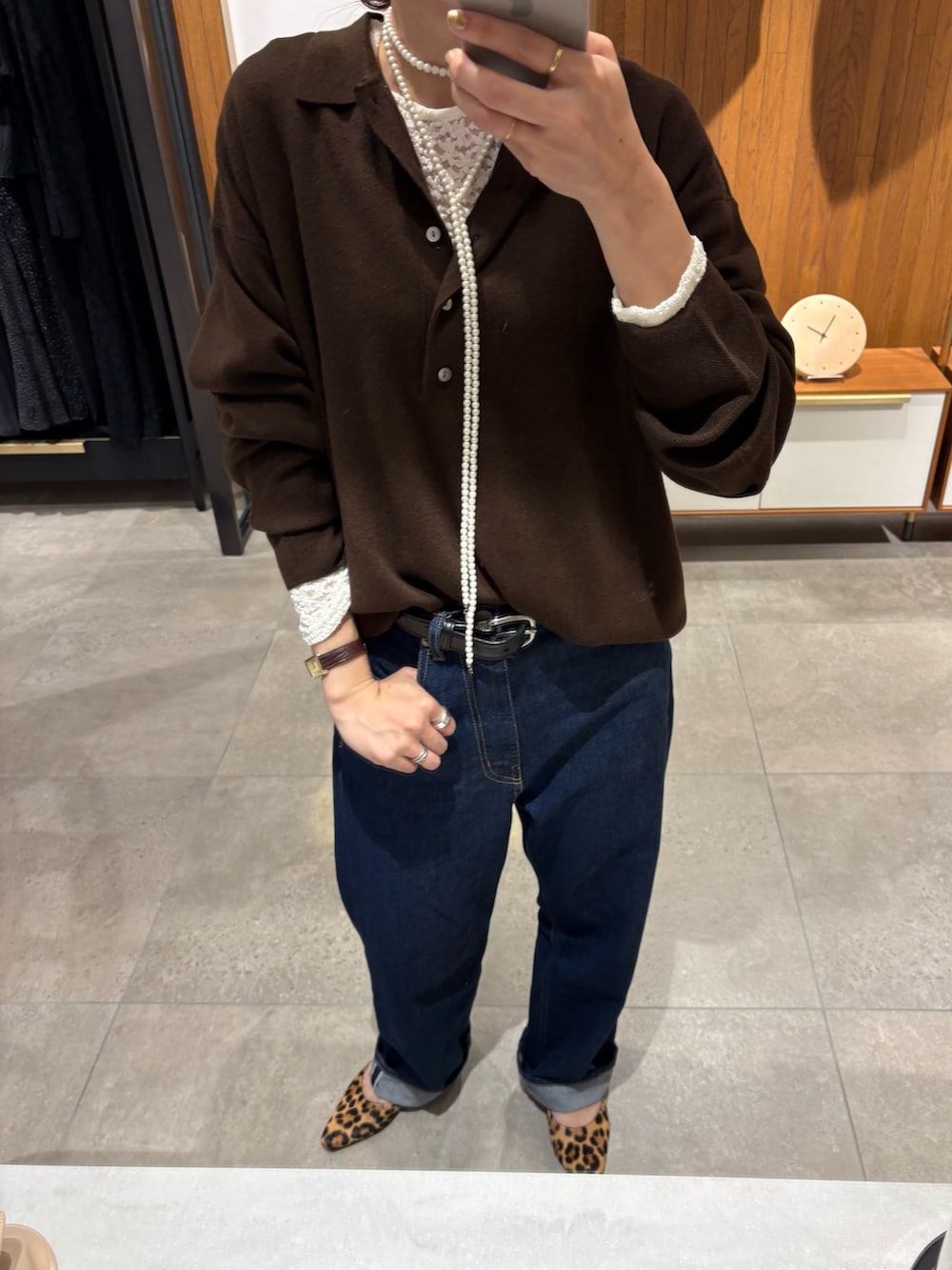 ブラウン系のニット/セーター、ホワイト系のTシャツ/カットソー、ブルー系のデニムパンツを着用したレディースの秋コーディネートの7枚目の写真