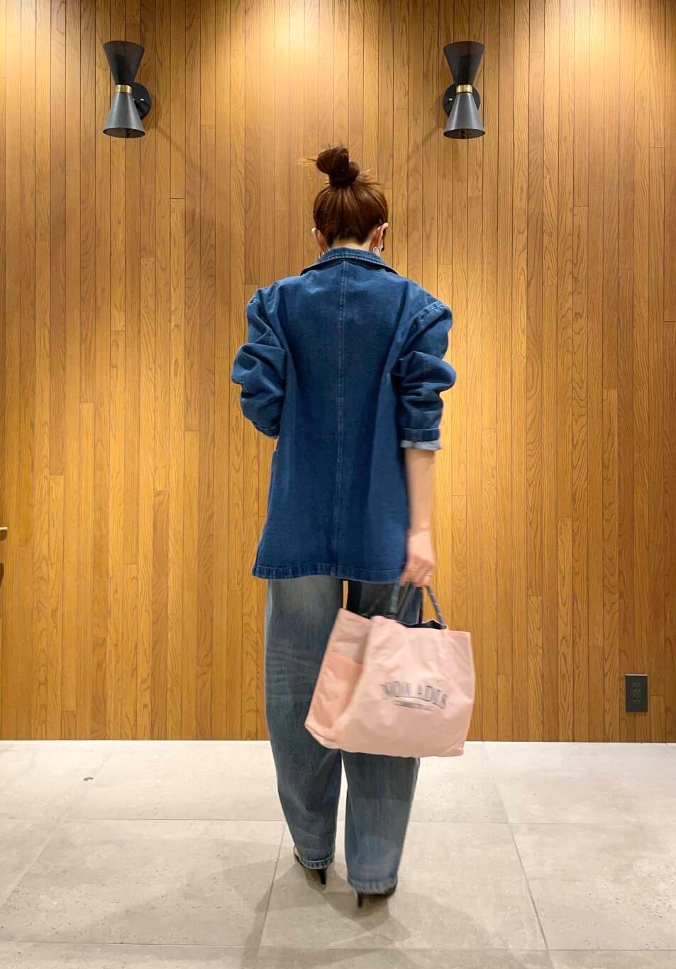 ブルー系のデニムパンツ、ブルー系のデニムジャケット、ホワイト系のキャミソールを着用したレディースの冬コーディネートの3枚目の写真