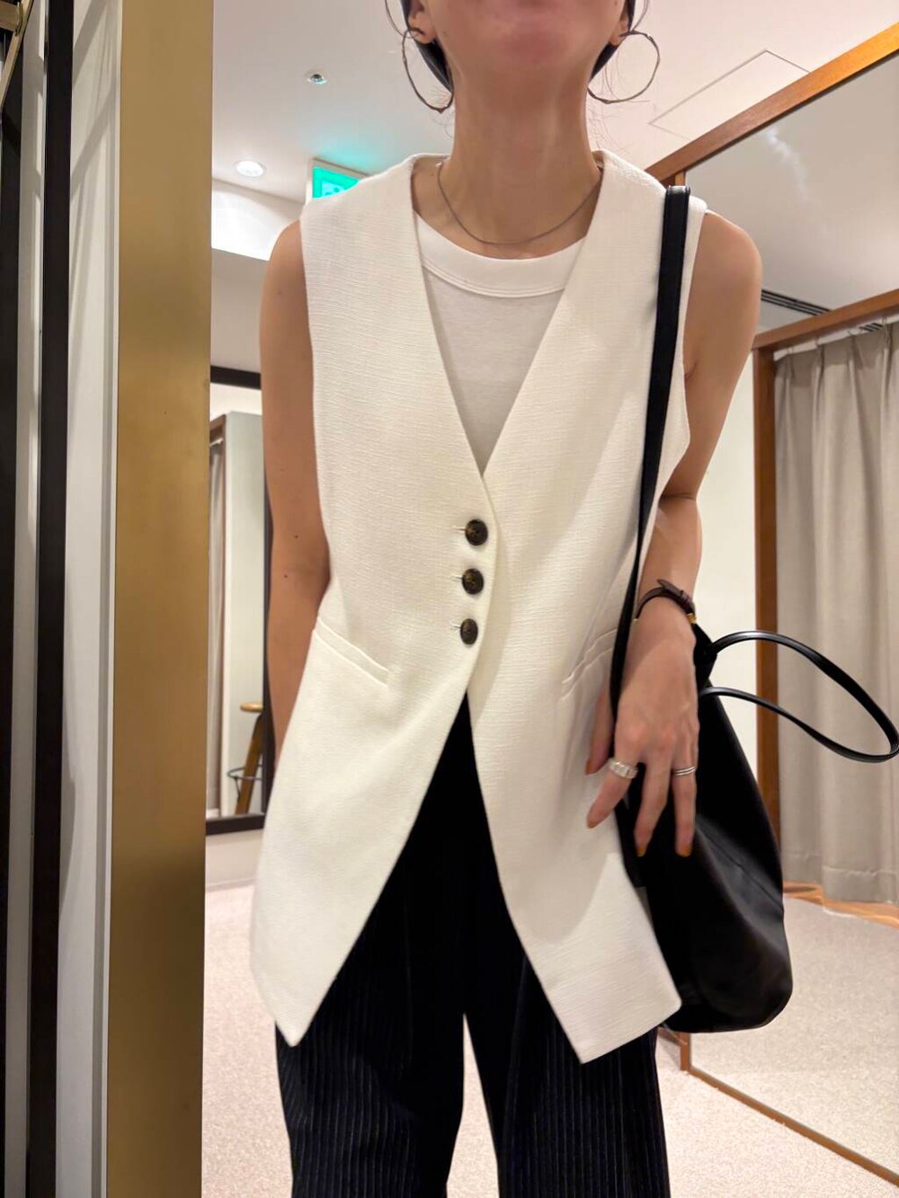 ブラック系のサンダル、ホワイト系のベスト、その他のその他パンツを着用したレディースの夏コーディネートの7枚目の写真