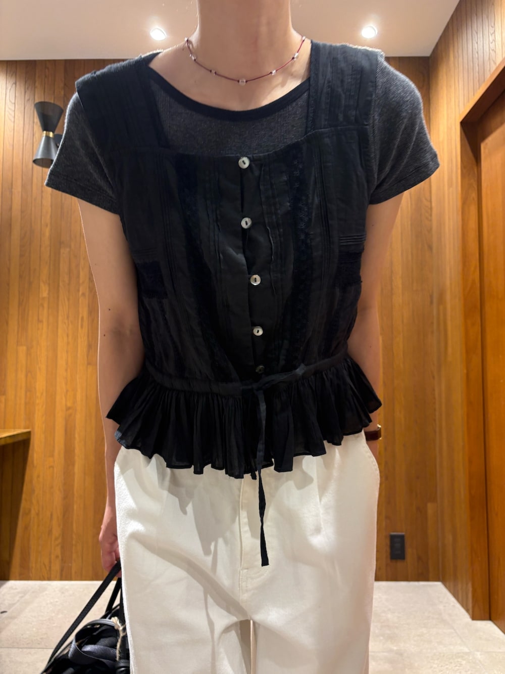 ホワイト系のデニムパンツ、ベージュ系のサンダル、ブラック系のかごバッグを着用したレディースの夏コーディネートの6枚目の写真