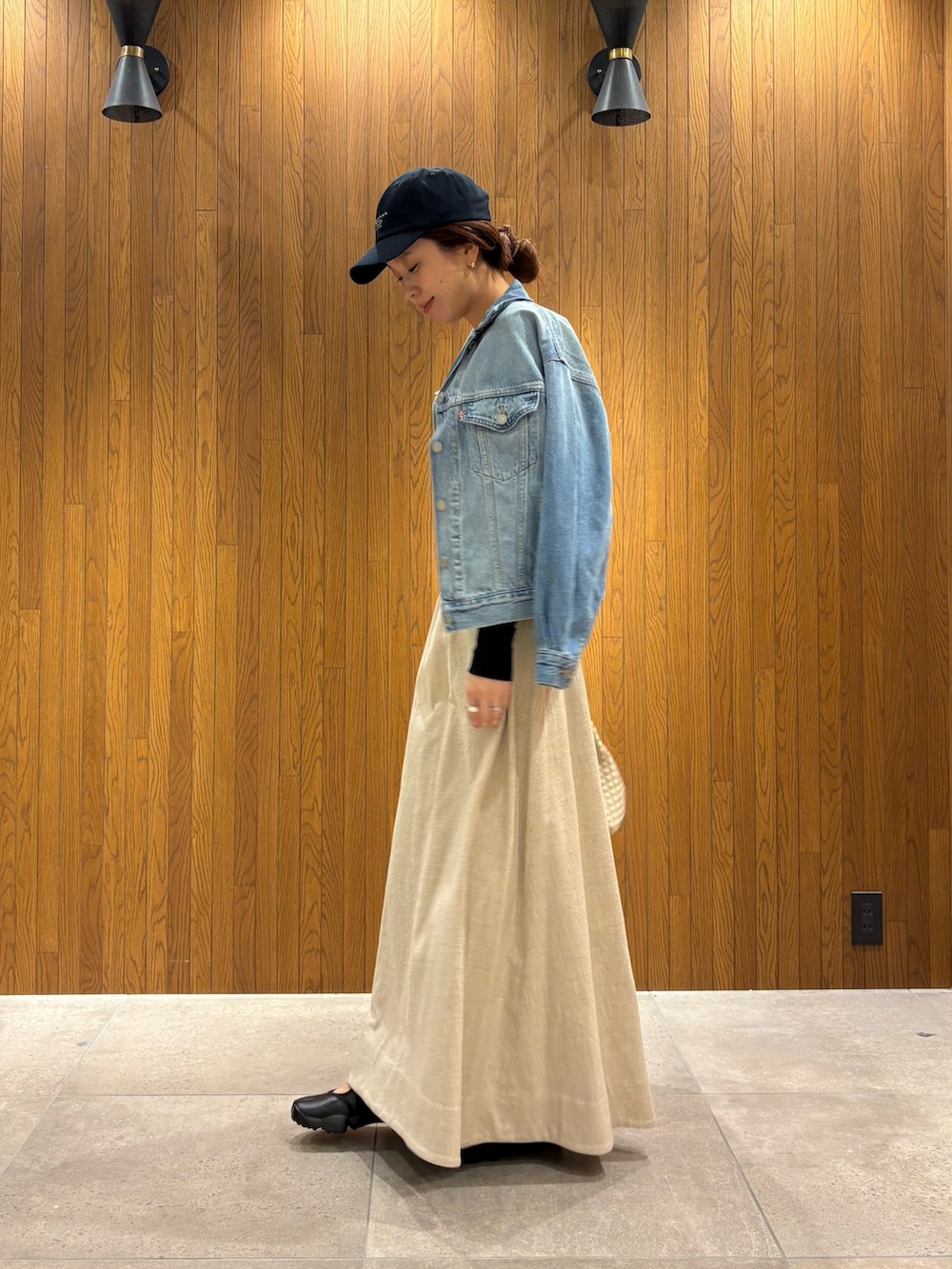 ホワイト系のトートバッグ、ブラック系のTシャツ/カットソー、ブルー系のデニムジャケットを着用したレディースの春コーディネートの2枚目の写真