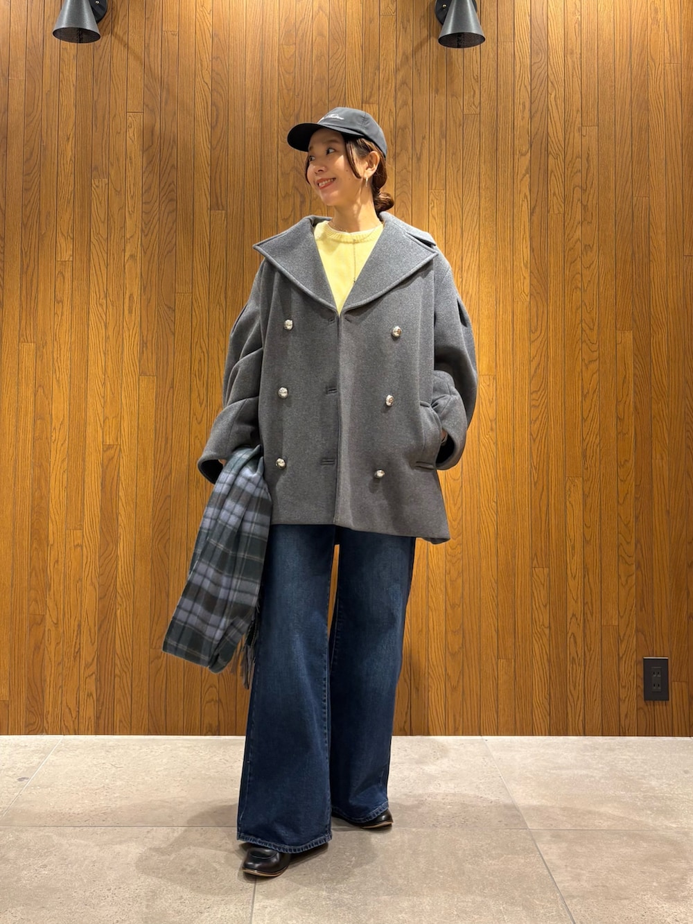 グレー系のその他アウター、イエロー系のニット/セーター、ブルー系のデニムパンツを着用したレディースの冬コーディネートの4枚目の写真