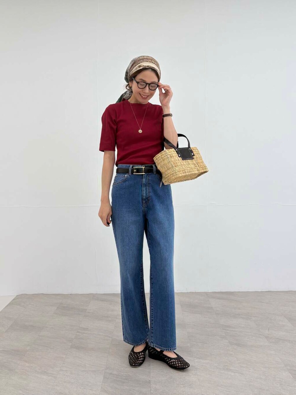 ブラック系のかごバッグ、ブルー系のデニムパンツ、レッド系のTシャツ/カットソーを着用したレディースの夏コーディネートの2枚目の写真