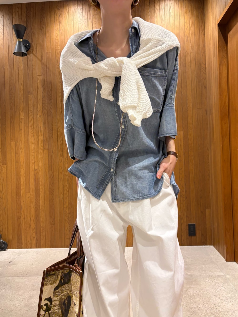 ブルー系のシャツ/ブラウス、ホワイト系のその他パンツ、ベージュ系のハンドバッグを着用したレディースの春コーディネートの6枚目の写真