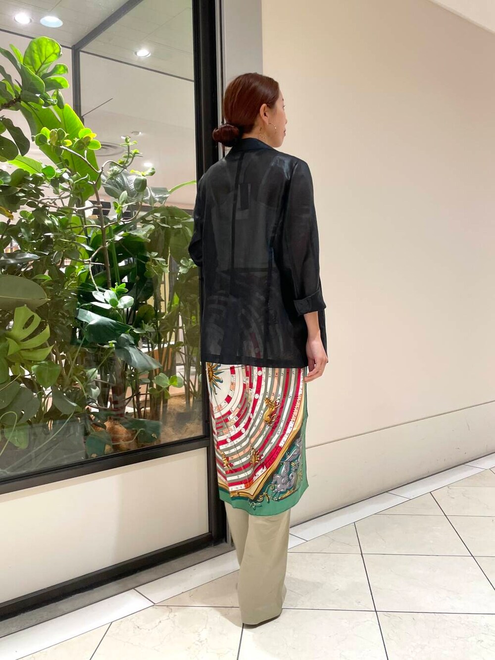 ホワイト系のタンクトップ、ブラック系のテーラードジャケット、ベージュ系のチノパンツを着用したレディースの夏コーディネートの5枚目の写真