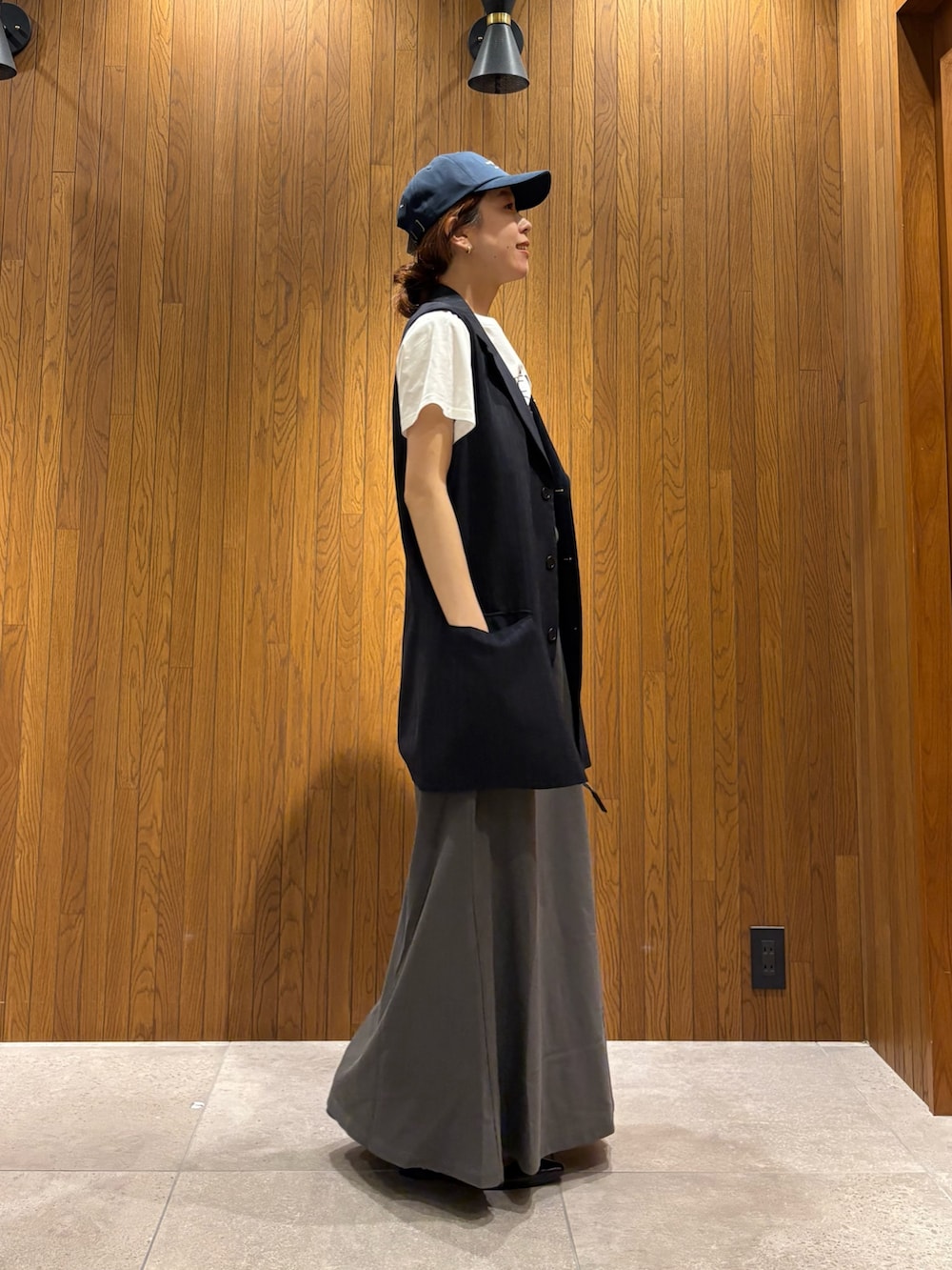 グレー系のスカート、その他のTシャツ/カットソー、ブラック系のハンドバッグを着用したレディースの春コーディネートの2枚目の写真