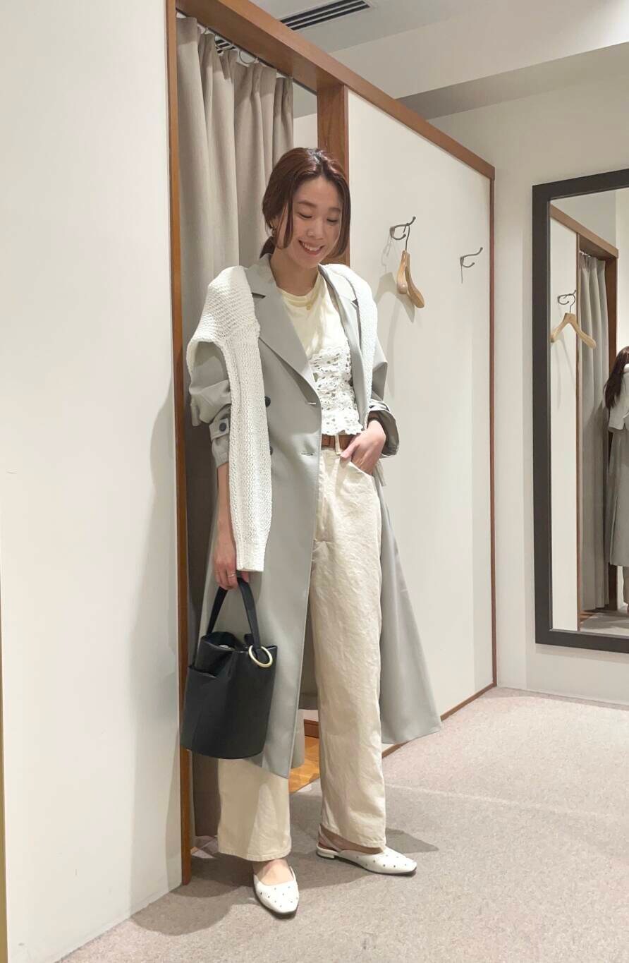 イエロー系のTシャツ/カットソー、グリーン系のトレンチコート、ホワイト系のニット/セーターを着用したレディースの春コーディネートの4枚目の写真