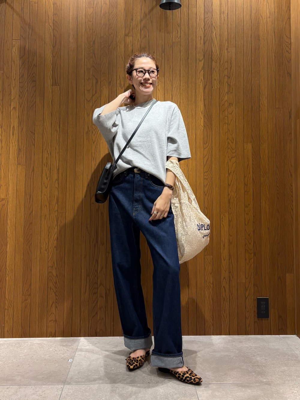 ホワイト系のハンドバッグ、ブルー系のデニムパンツ、ブラック系のショルダーバッグを着用したレディースの秋コーディネートの5枚目の写真