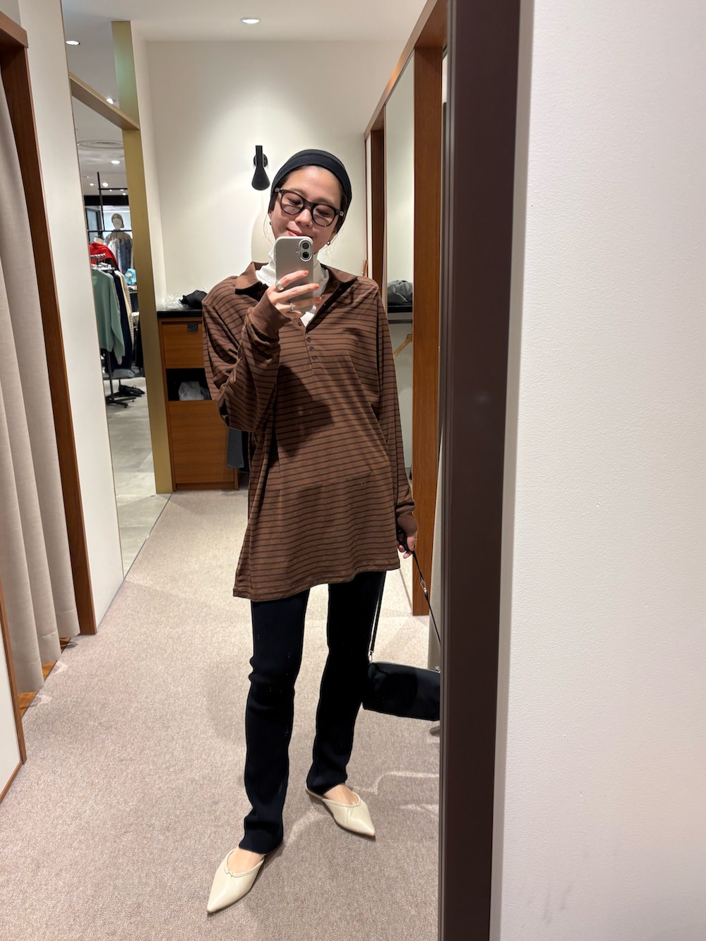 ブラウン系のポロシャツ、ブラック系のその他パンツ、ブラック系のハンドバッグを着用したレディースの秋コーディネートの10枚目の写真