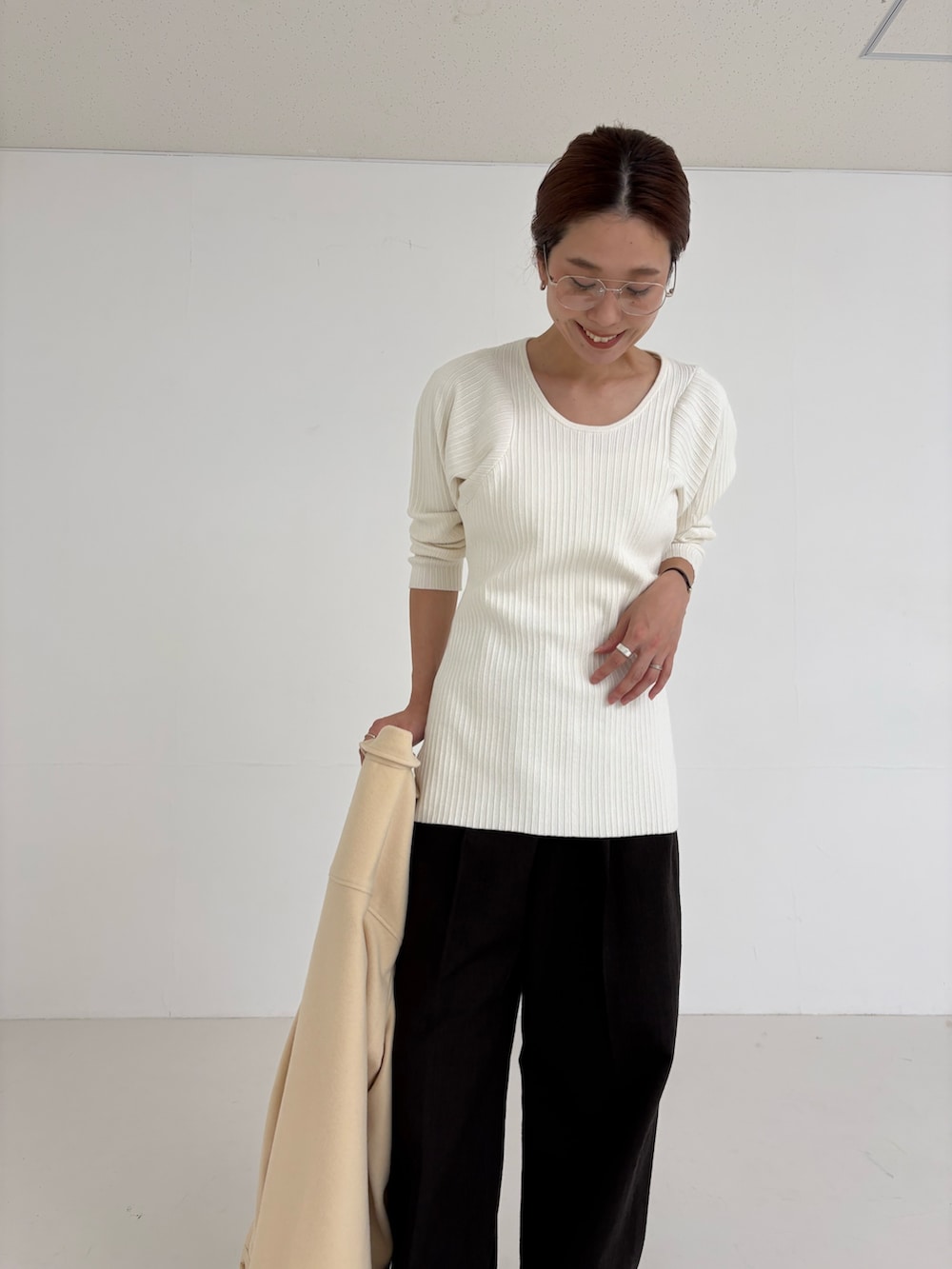 ホワイト系のニット/セーター、ブラウン系のその他パンツ、ゴールド系のメガネを着用したレディースの秋コーディネートの7枚目の写真