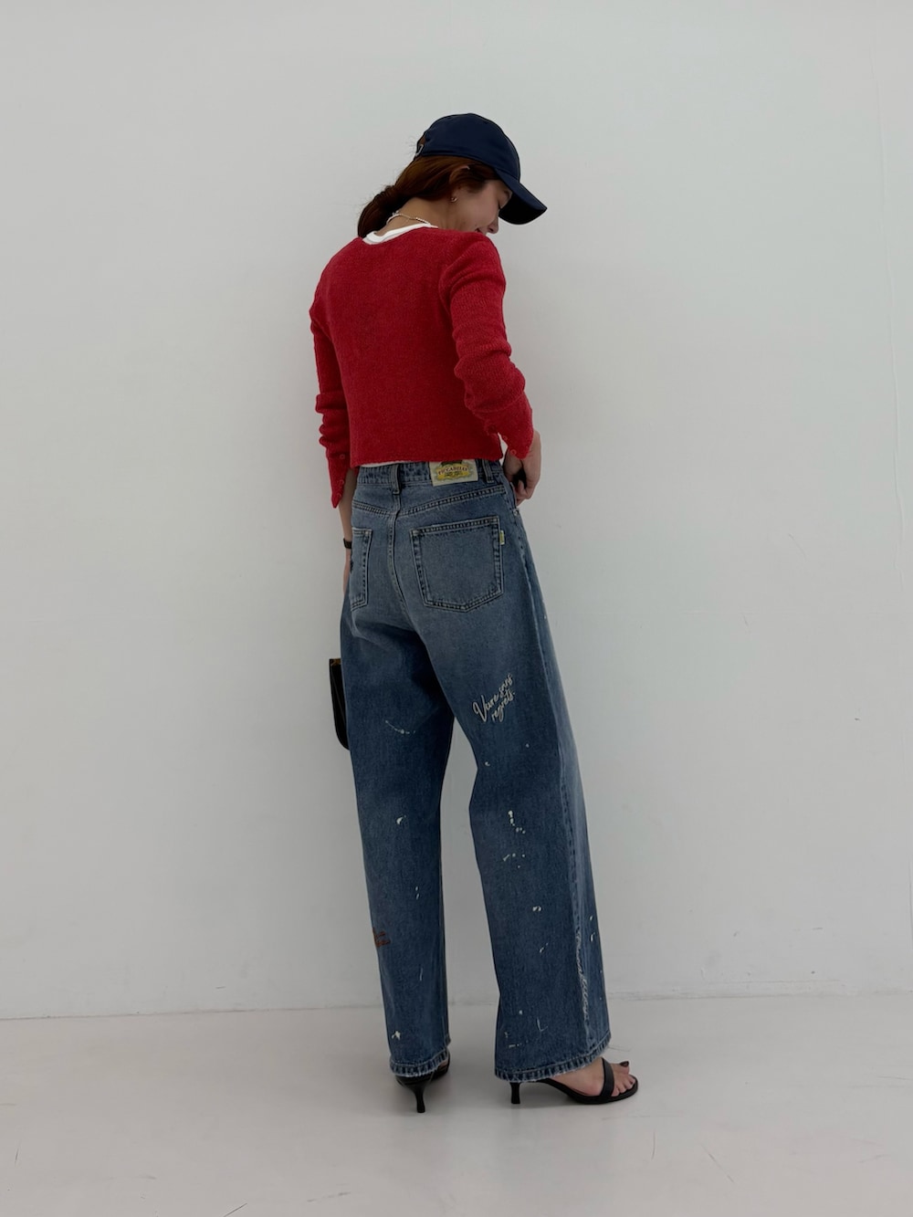 ブルー系のデニムパンツ、ホワイト系のTシャツ/カットソー、ブラック系のハンドバッグを着用したレディースの夏コーディネートの5枚目の写真