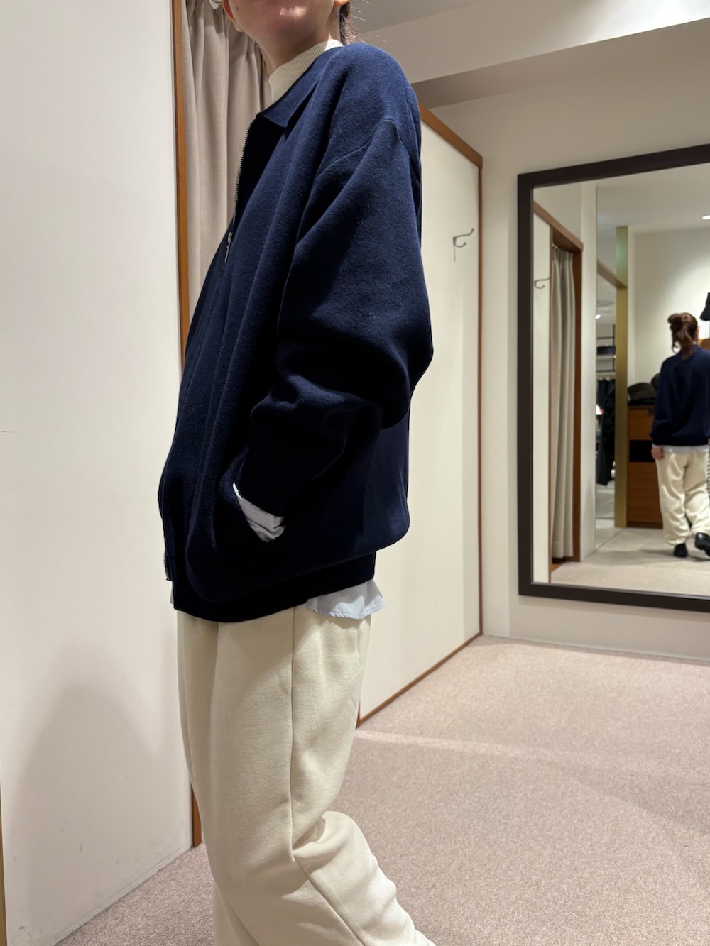 ブラック系のチェスターコート、ホワイト系のその他パンツ、ブラック系のブーツを着用したレディースの冬コーディネートの6枚目の写真