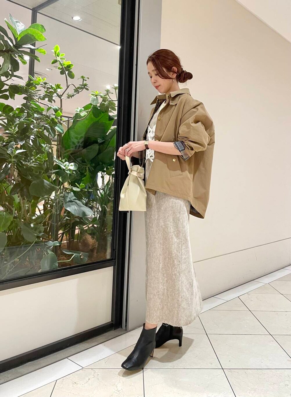 イエロー系のTシャツ/カットソー、ベージュ系のワンピース、ホワイト系のニット/セーターを着用したレディースの冬コーディネートの6枚目の写真