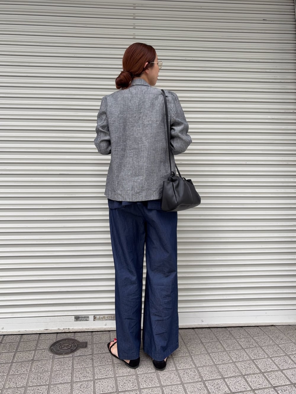 グレー系のその他アウター、ブラック系のサンダル、ブルー系のその他パンツを着用したレディースの春コーディネートの2枚目の写真