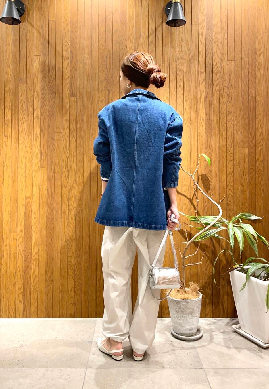 シルバー系のショルダーバッグ、ホワイト系のパンプス、ブルー系のデニムジャケットを着用したレディースの冬コーディネートの3枚目の写真