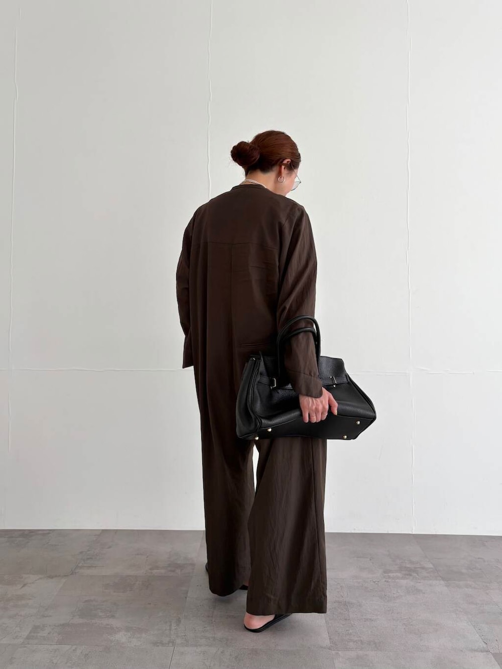 ブラウン系のサロペット/オーバーオール、ホワイト系のTシャツ/カットソー、ブラック系のサンダルを着用したレディースの春コーディネートの6枚目の写真