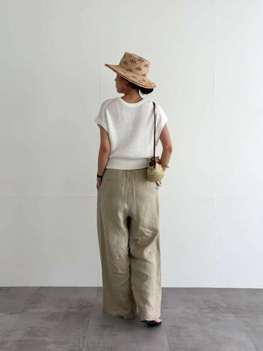 ベージュ系のその他パンツ、ホワイト系のベスト、ブラック系のサンダルを着用したレディースの夏コーディネートの3枚目の写真