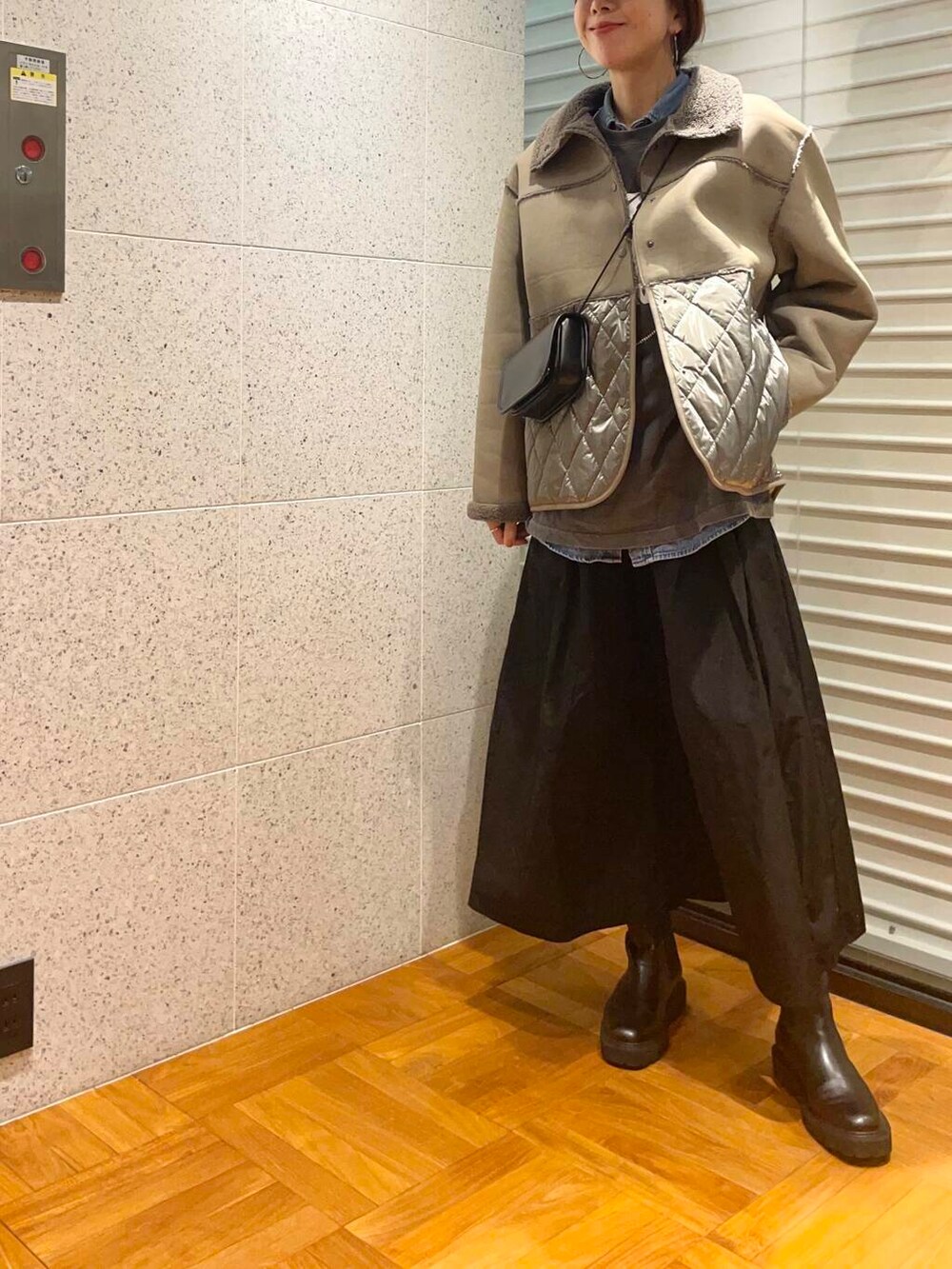 グレー系のその他アウター、ブラック系のブーツ、ブラック系のスカートを着用したレディースの冬コーディネートの2枚目の写真