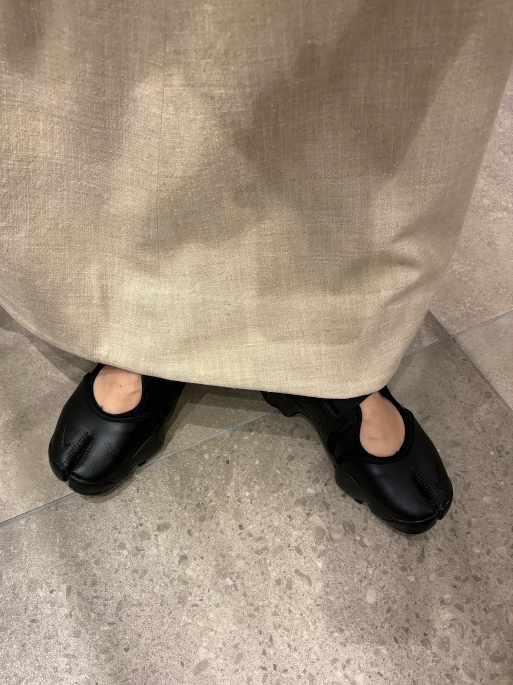 ベージュ系のスカート、ホワイト系のシャツ/ブラウス、ブラック系のショルダーバッグを着用したレディースの春コーディネートの6枚目の写真