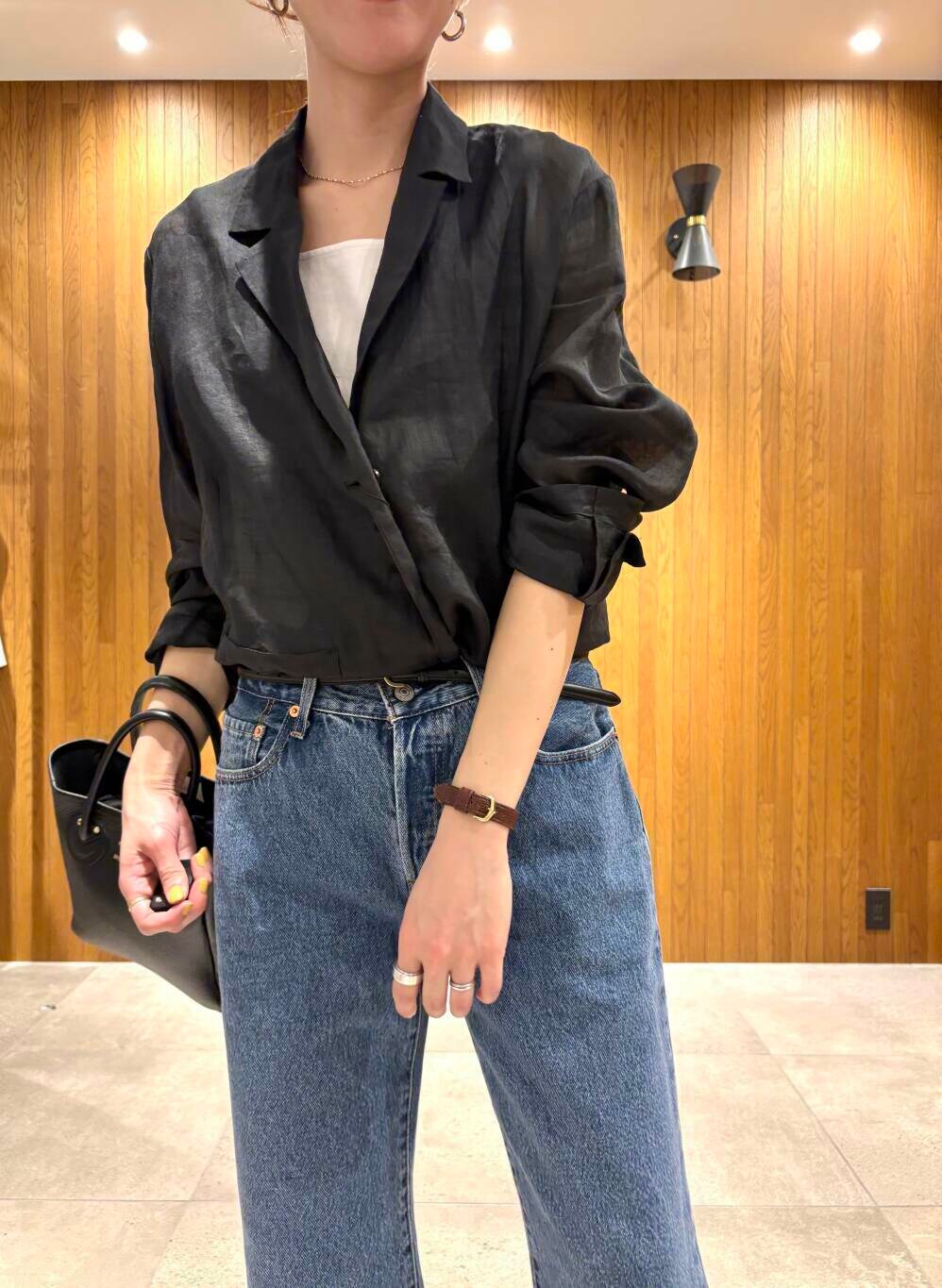 ブラック系のその他アウター、ブルー系のデニムパンツ、ベージュ系のキャップを着用したレディースの春コーディネートの7枚目の写真