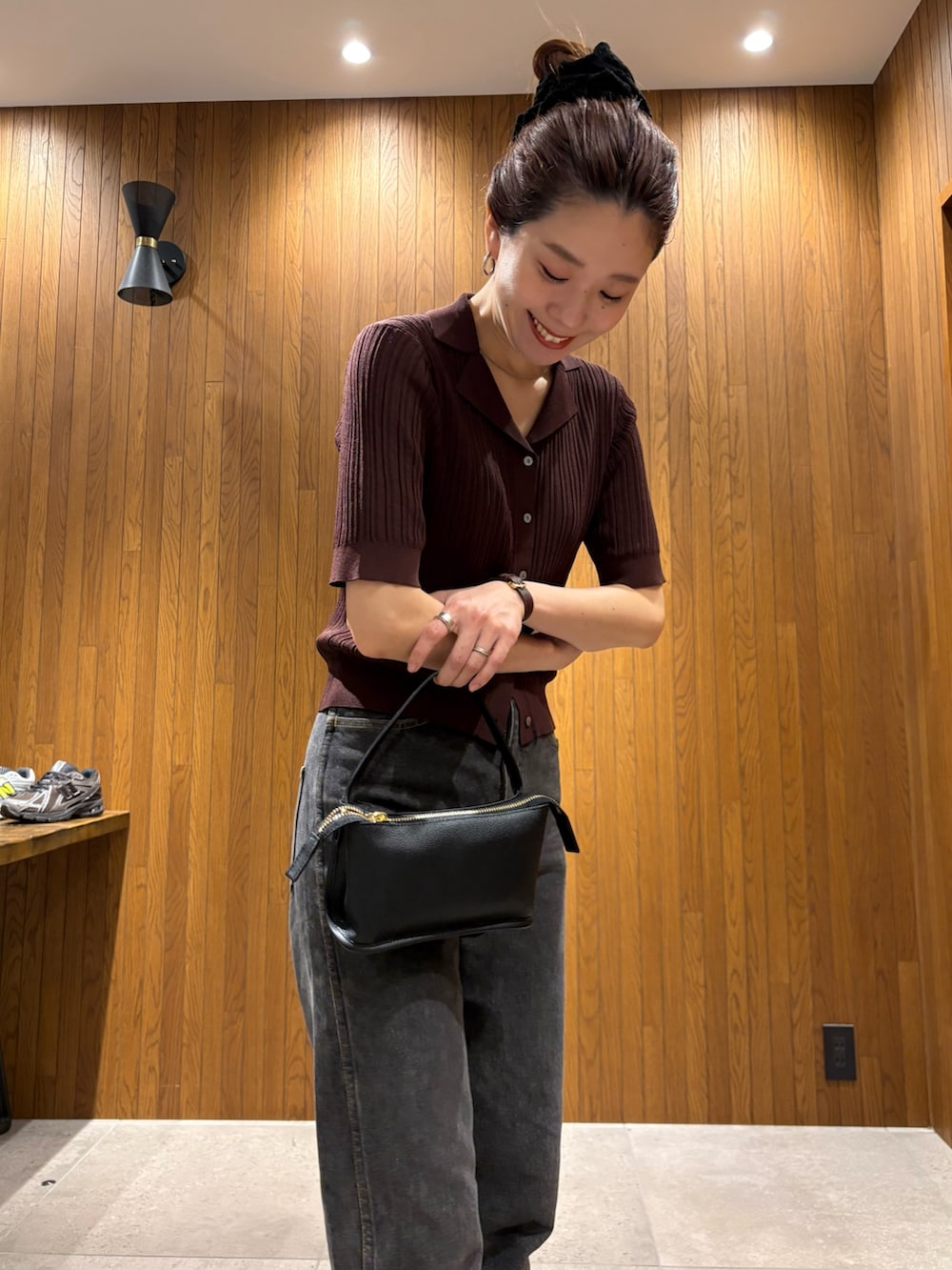 ブラウン系のニット/セーター、ブラック系のハンドバッグを着用したレディースの春コーディネートの6枚目の写真