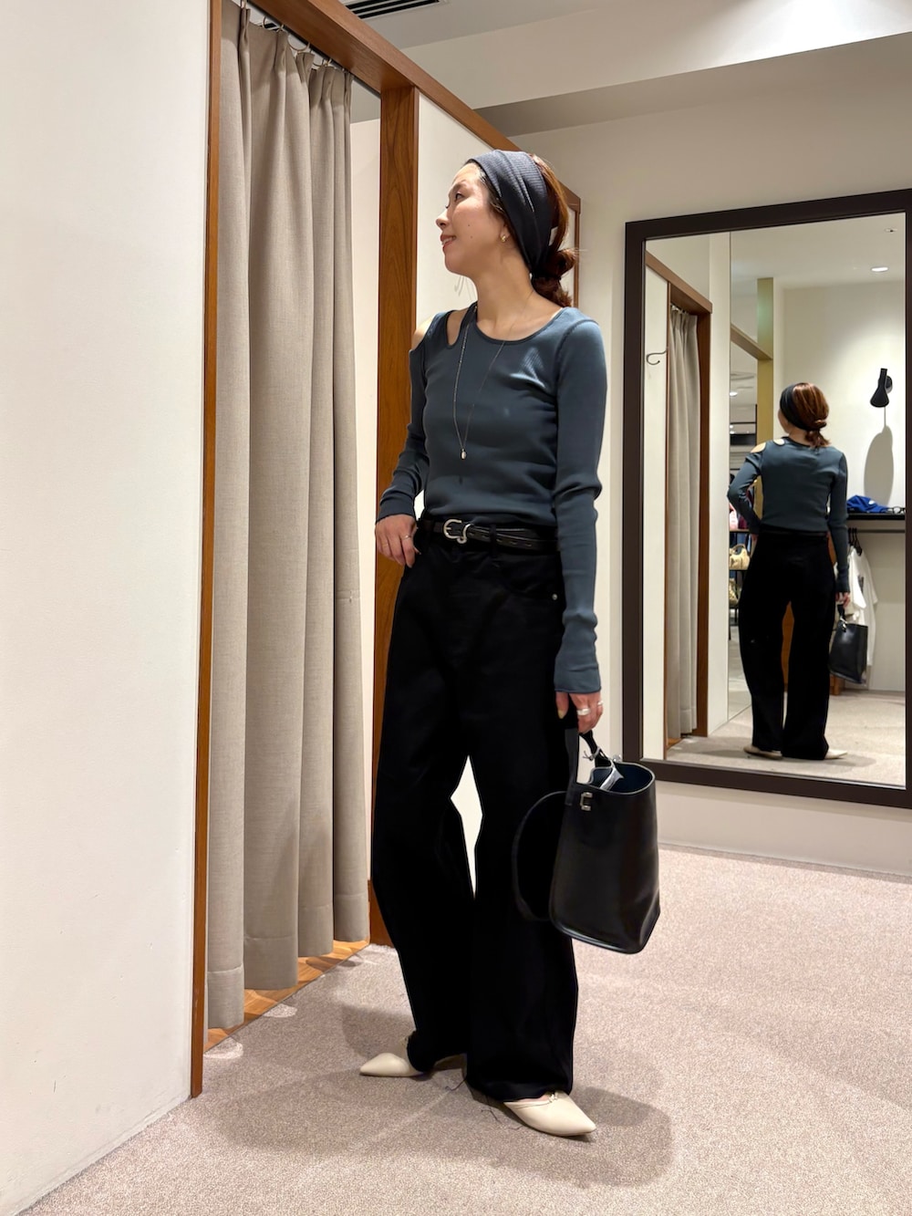 ブラック系のその他パンツ、ブラック系のトートバッグ、ブルー系のTシャツ/カットソーを着用したレディースの秋コーディネートの2枚目の写真