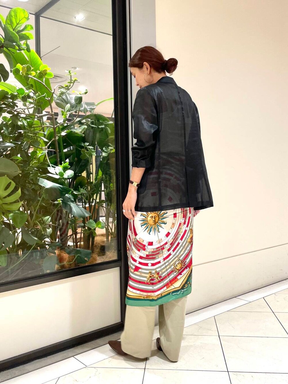 ホワイト系のタンクトップ、ブラック系のテーラードジャケット、ベージュ系のチノパンツを着用したレディースの夏コーディネートの3枚目の写真