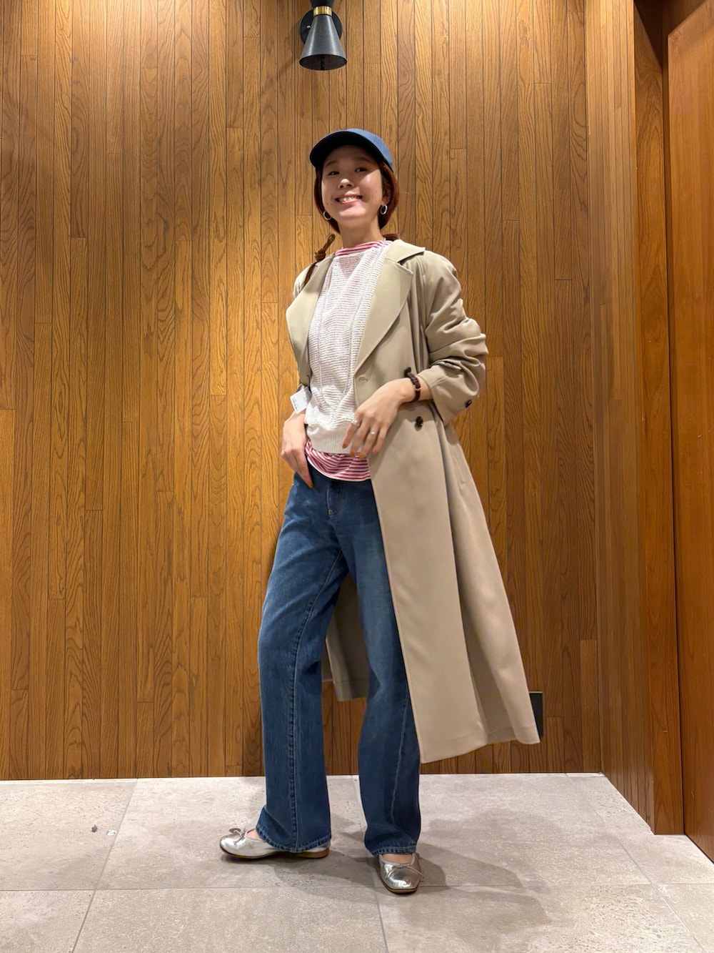 ベージュ系のトレンチコート、レッド系のTシャツ/カットソー、ホワイト系のニット/セーターを着用したレディースの春コーディネートの2枚目の写真