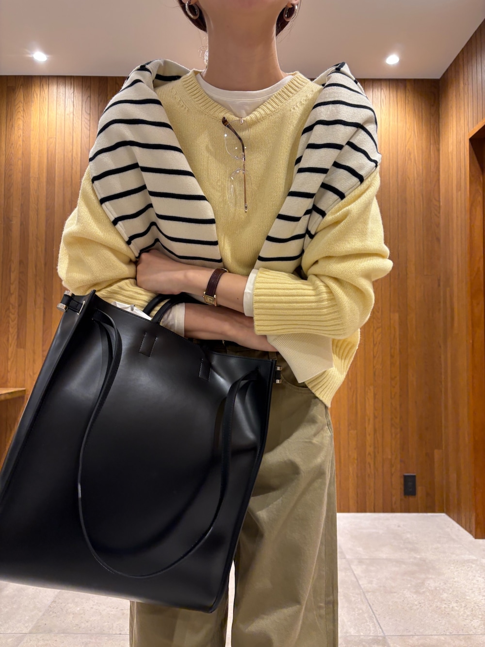 イエロー系のニット/セーター、ベージュ系のその他パンツ、ブラック系のハンドバッグを着用したレディースの冬コーディネートの5枚目の写真