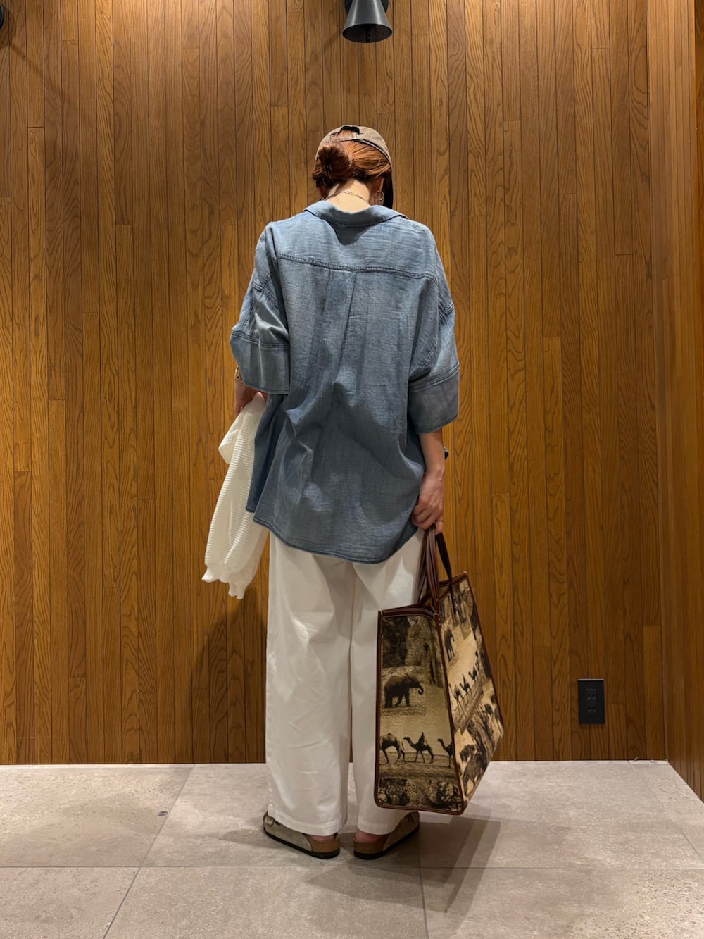 ブルー系のシャツ/ブラウス、ホワイト系のその他パンツ、ベージュ系のハンドバッグを着用したレディースの春コーディネートの3枚目の写真