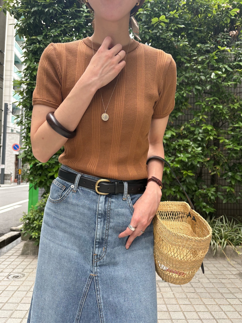 イエロー系のニット/セーター、ベージュ系のかごバッグ、ブラウン系のサンダルを着用したレディースの夏コーディネートの9枚目の写真