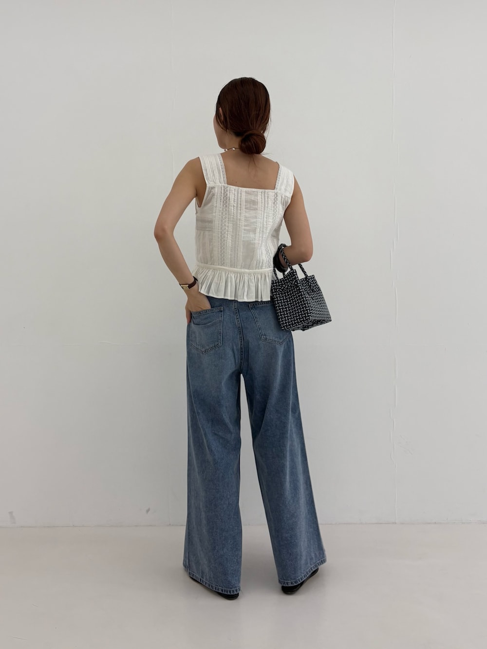 ブルー系のデニムパンツ、その他のトートバッグ、ホワイト系のシャツ/ブラウスを着用したレディースの夏コーディネートの3枚目の写真
