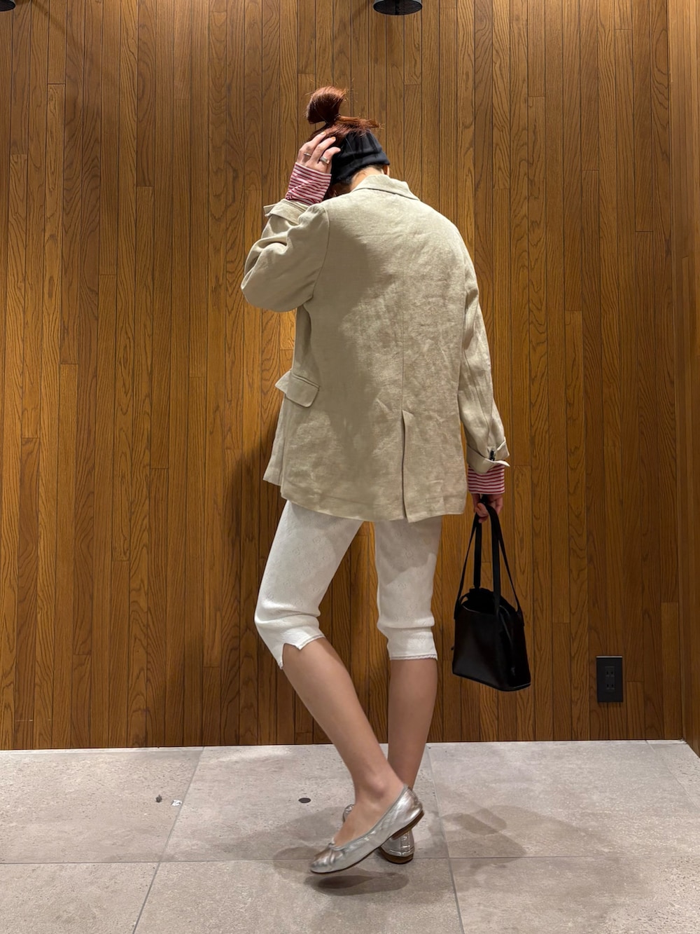 ベージュ系のその他アウター、レッド系のTシャツ/カットソー、ブラック系のハンドバッグを着用したレディースの春コーディネートの2枚目の写真