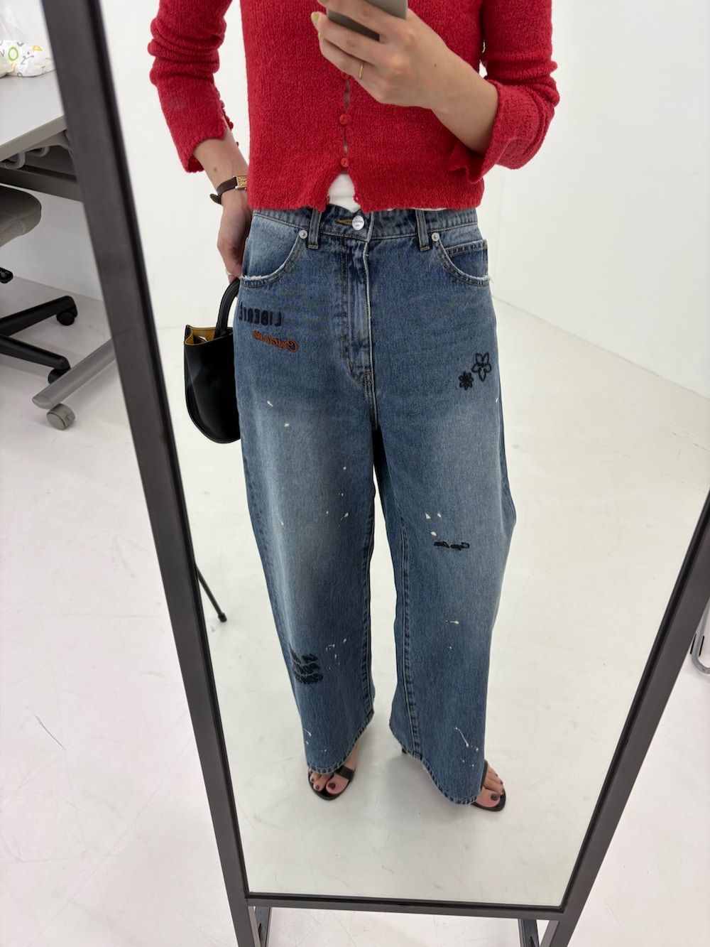 ブルー系のデニムパンツ、ホワイト系のTシャツ/カットソー、ブラック系のハンドバッグを着用したレディースの夏コーディネートの9枚目の写真