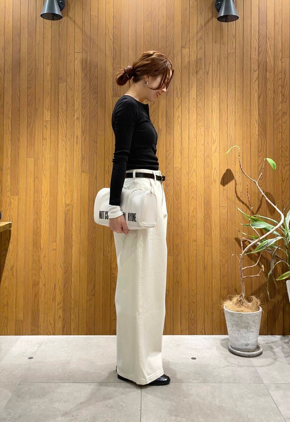 ブラック系のローファー、ホワイト系のボストンバッグ、ホワイト系のデニムパンツを着用したレディースの冬コーディネートの3枚目の写真