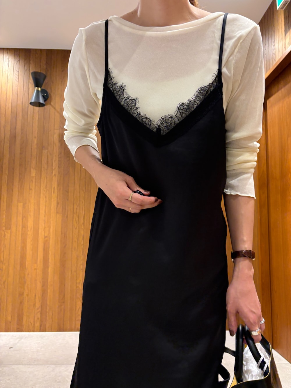 ブラック系のワンピース、ブルー系のデニムパンツ、ブラック系のショルダーバッグを着用したレディースの秋コーディネートの6枚目の写真