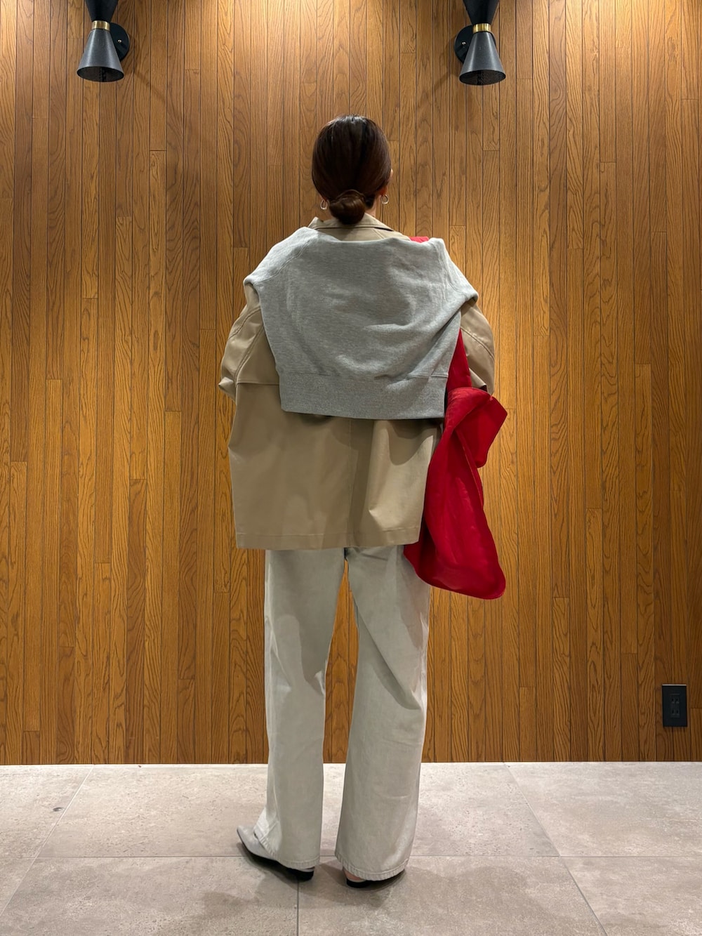 ベージュ系のトレンチコート、グレー系のデニムパンツ、シルバー系のパンプスを着用したレディースの冬コーディネートの3枚目の写真