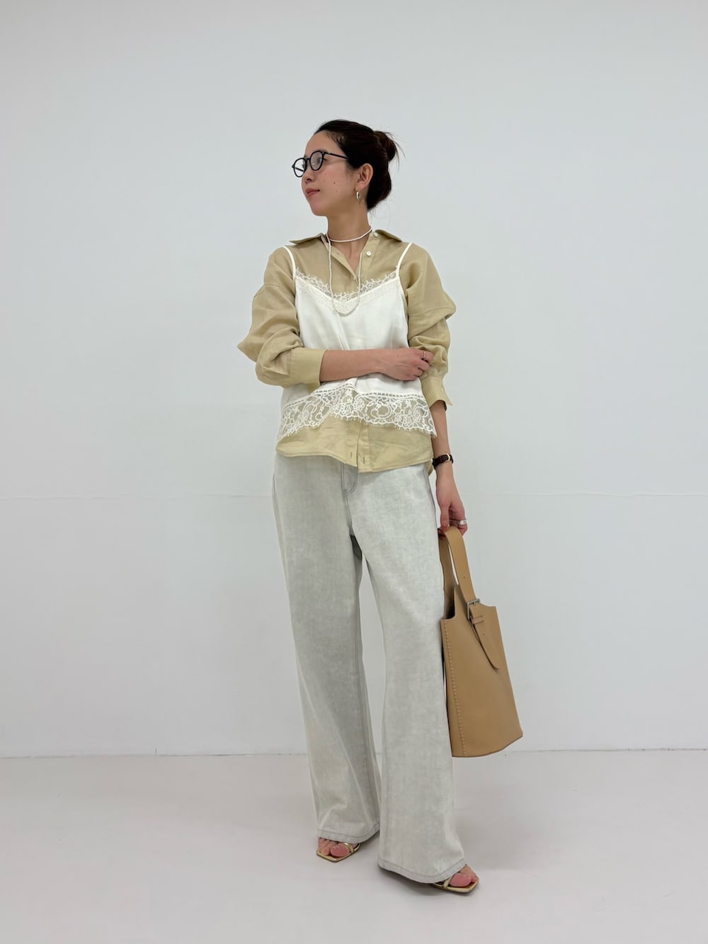 ホワイト系のキャミソール、グレー系のデニムパンツ、ベージュ系のシャツ/ブラウスを着用したレディースの冬コーディネートの5枚目の写真