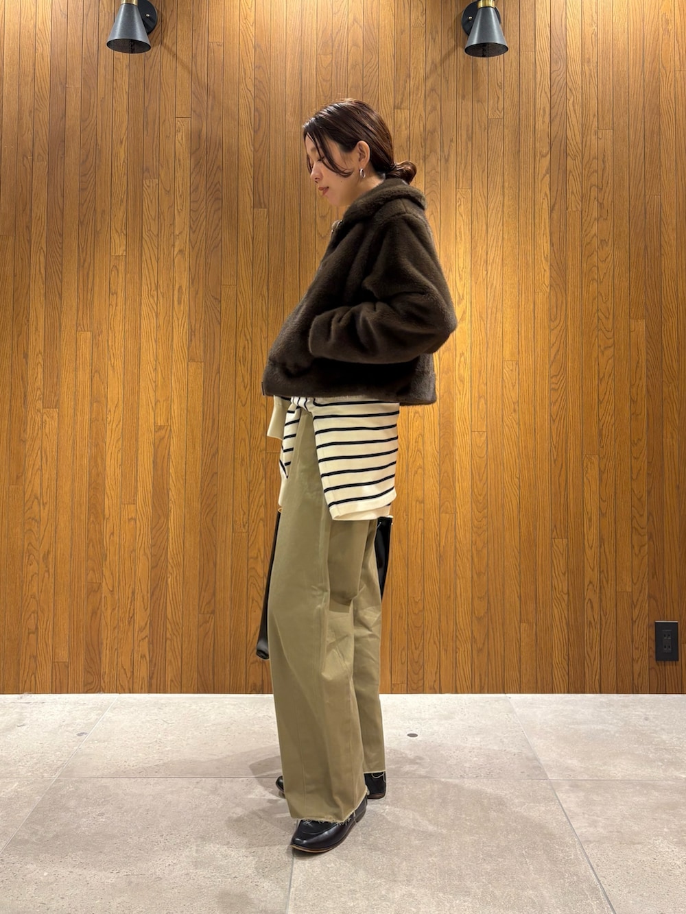 イエロー系のニット/セーター、ベージュ系のその他パンツ、ブラック系のハンドバッグを着用したレディースの冬コーディネートの9枚目の写真