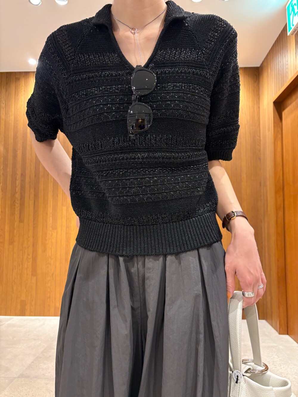 グレー系のその他パンツ、ブラック系のニット/セーター、ホワイト系のハンドバッグを着用したレディースの春コーディネートの5枚目の写真