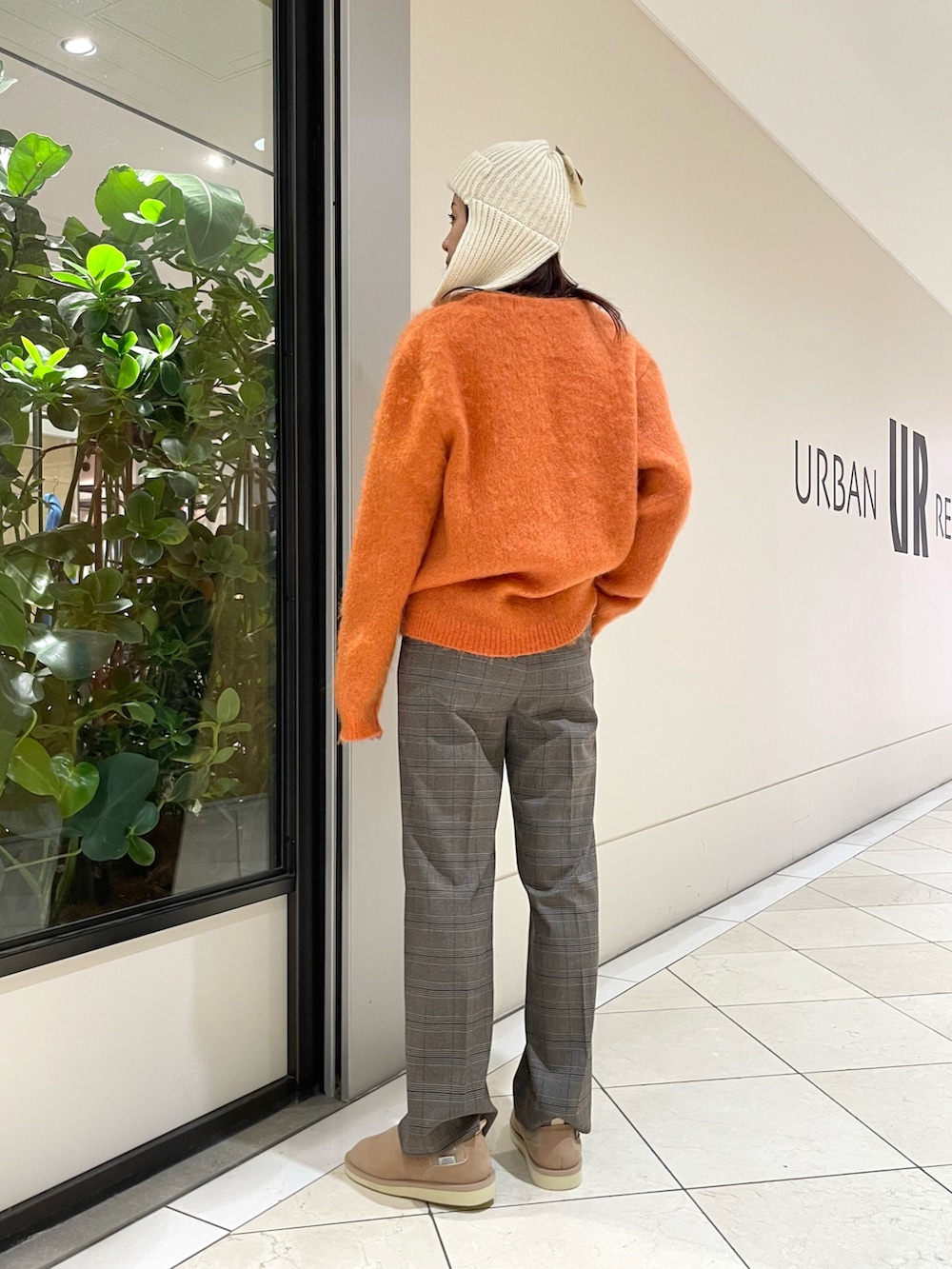 ブラウン系のその他パンツ、オレンジ系のカーディガン/ボレロ、ベージュ系のスリッポンを着用したレディースの冬コーディネートの2枚目の写真