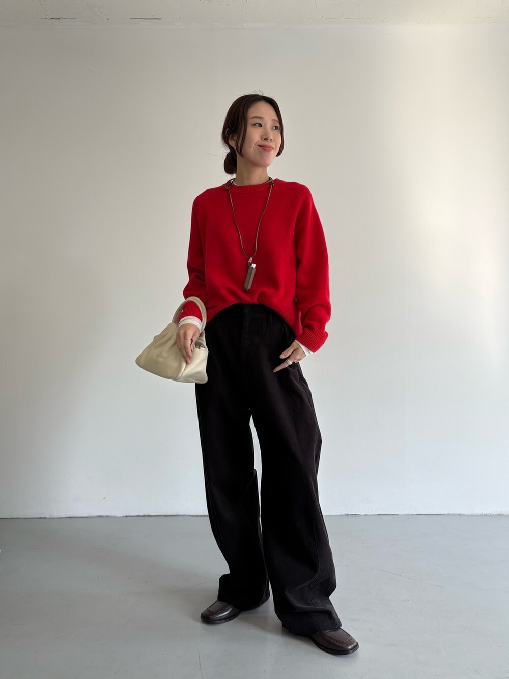 グレー系のその他パンツ、レッド系のニット/セーター、ブラック系のハンドバッグを着用したレディースの冬コーディネートの8枚目の写真