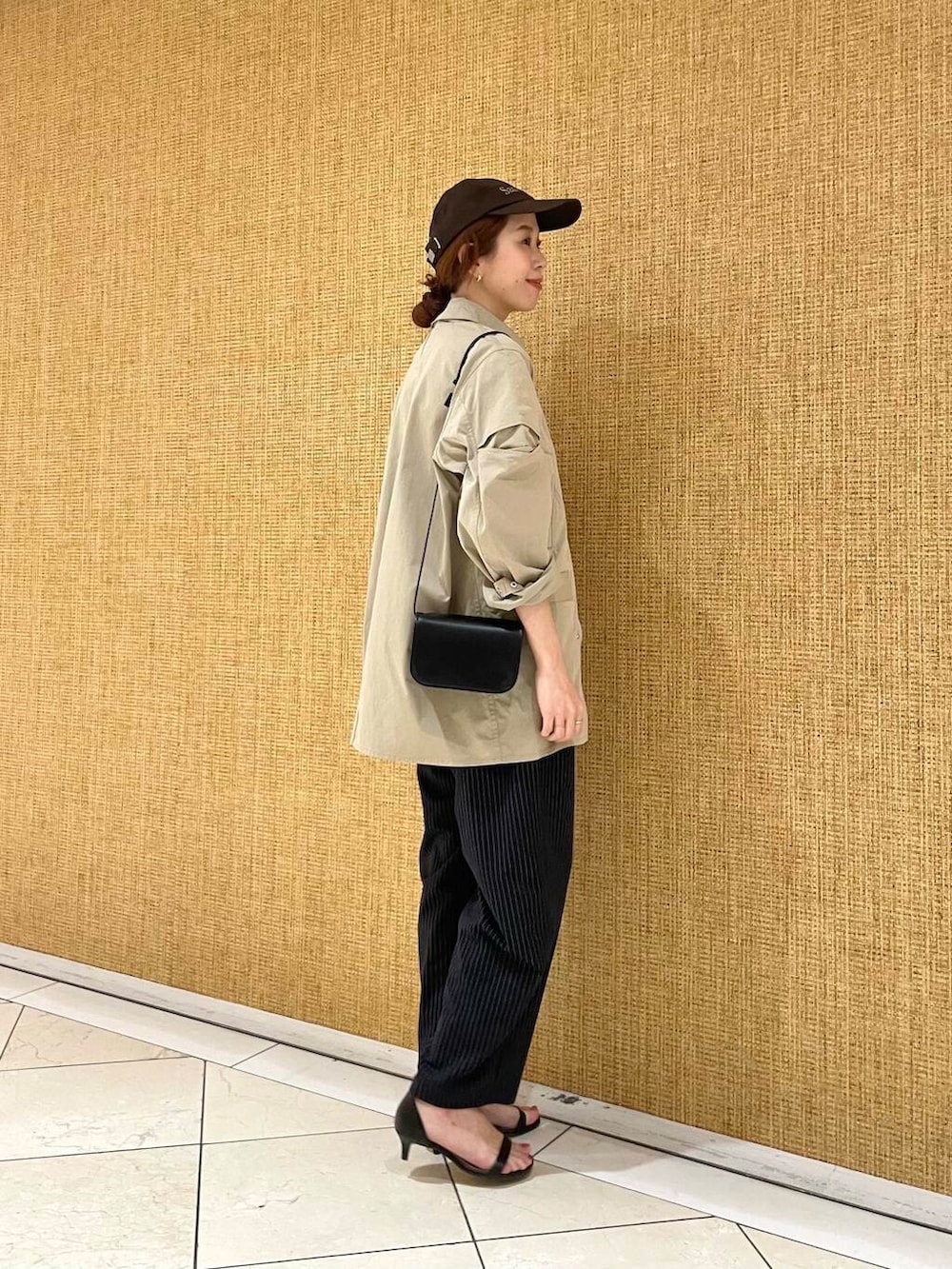 ブラック系のショルダーバッグ、ブルー系のその他パンツ、ブラウン系のその他アウターを着用したレディースの冬コーディネートの2枚目の写真