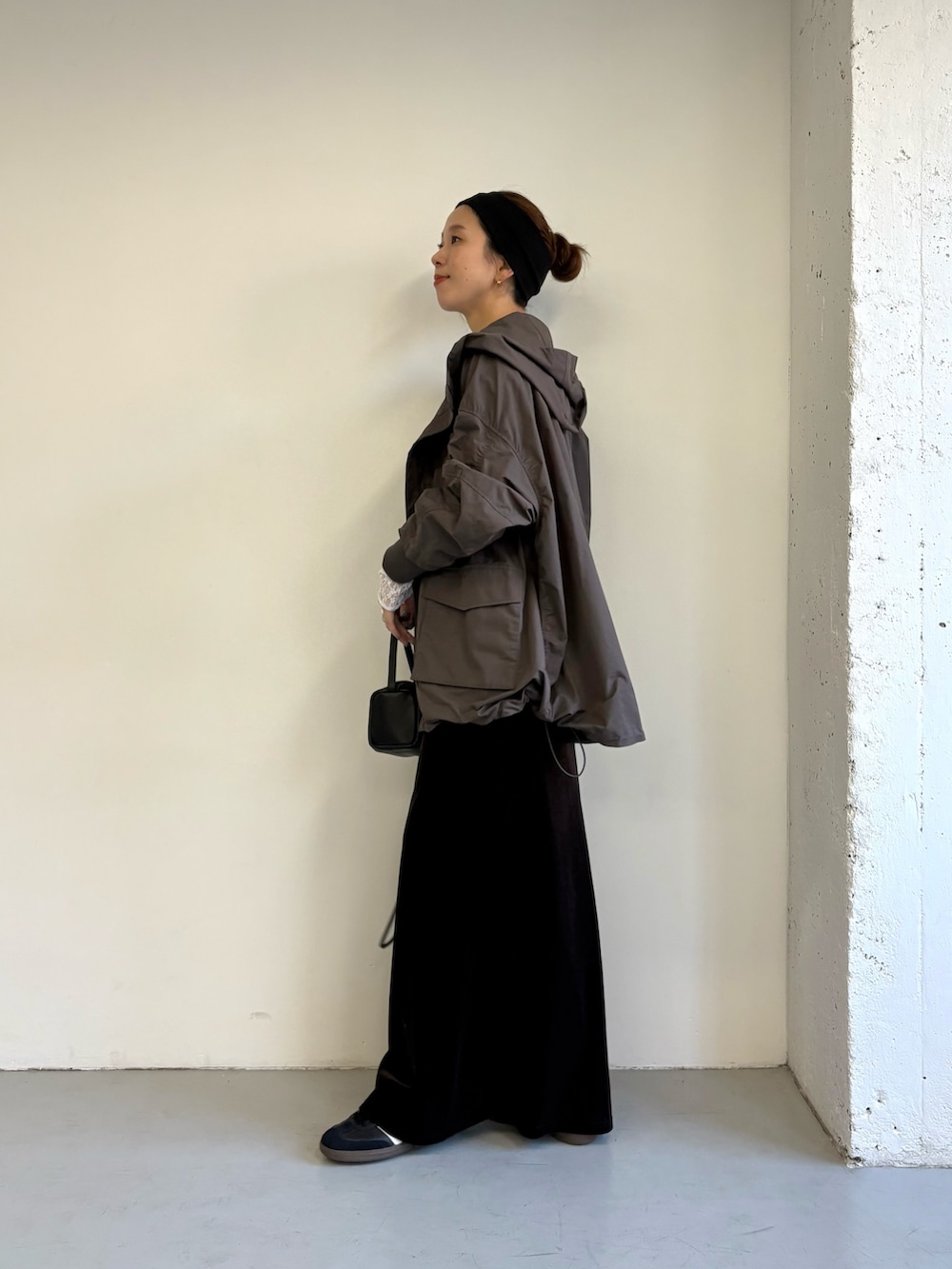 ブルー系のTシャツ/カットソー、グレー系のマウンテンパーカー、ブラック系のスニーカーを着用したレディースの秋コーディネートの5枚目の写真