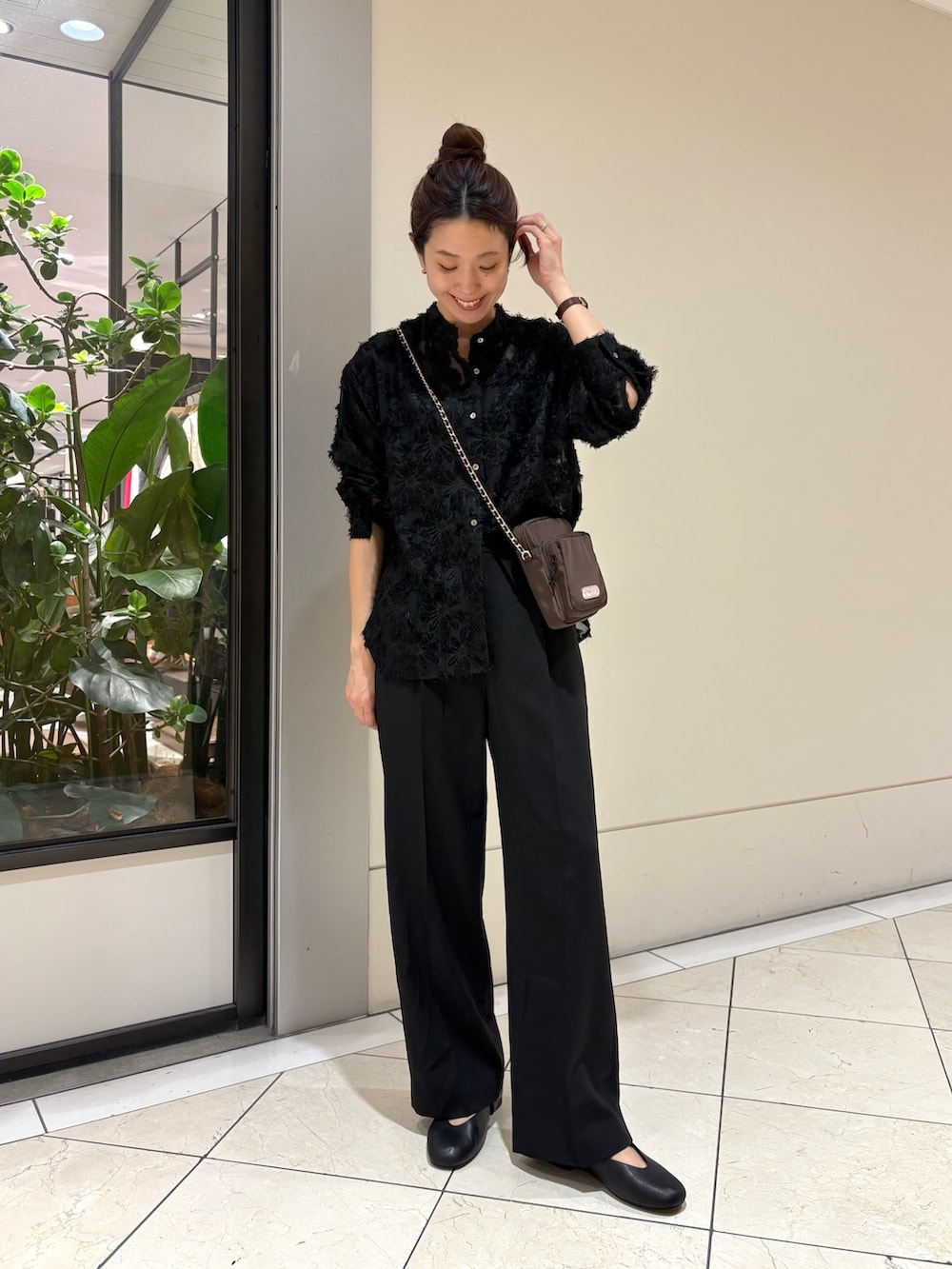 ブラック系のシャツ/ブラウス、ブラック系のスラックス、ブラウン系のショルダーバッグを着用したレディースの冬コーディネートの4枚目の写真