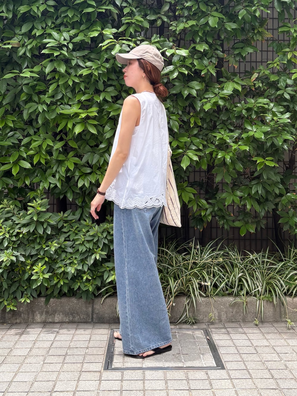 ホワイト系のシャツ/ブラウス、ブルー系のデニムパンツ、ホワイト系のトートバッグを着用したレディースの夏コーディネートの3枚目の写真