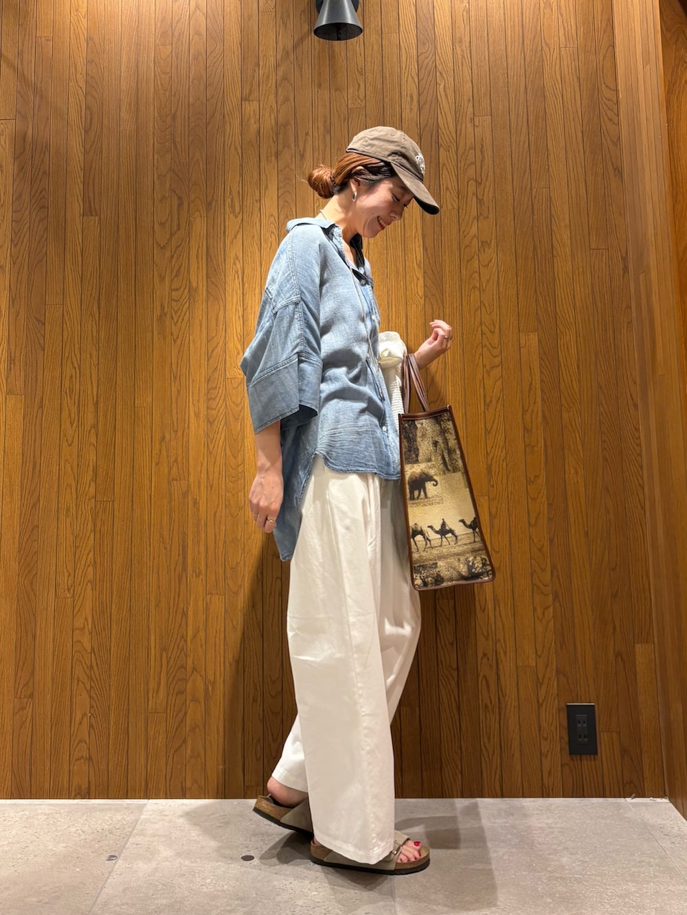 ブルー系のシャツ/ブラウス、ホワイト系のその他パンツ、ベージュ系のハンドバッグを着用したレディースの春コーディネートの4枚目の写真