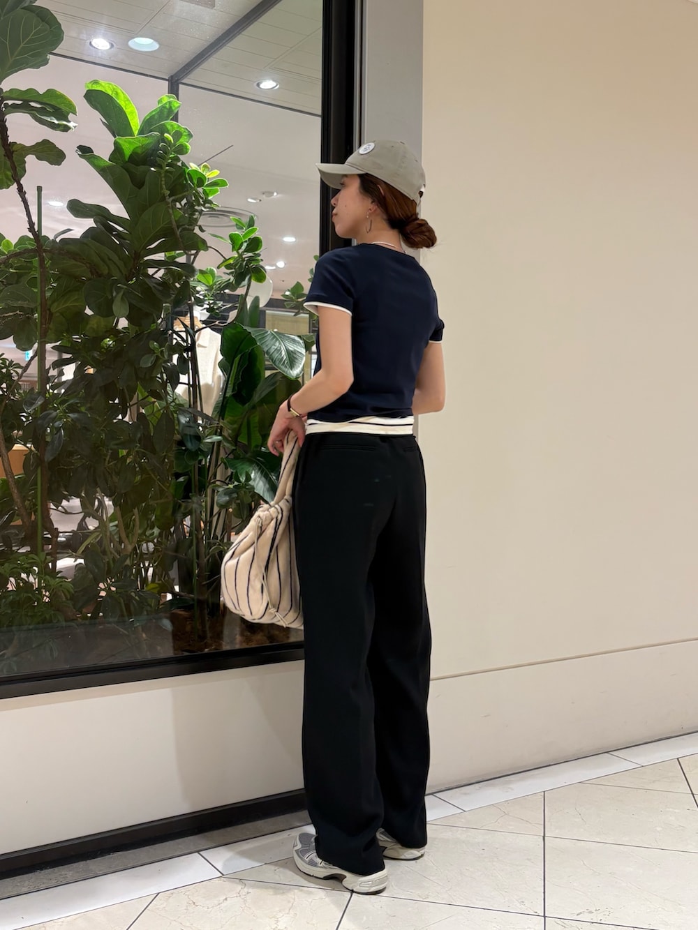 ブラック系のその他パンツ、グレー系のスニーカー、ホワイト系のハンドバッグを着用したレディースの夏コーディネートの2枚目の写真